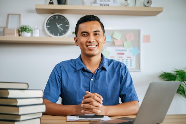 Ein Mann, der im Büro mit Papieren und Laptop auf dem Schreibtisch arbeitet