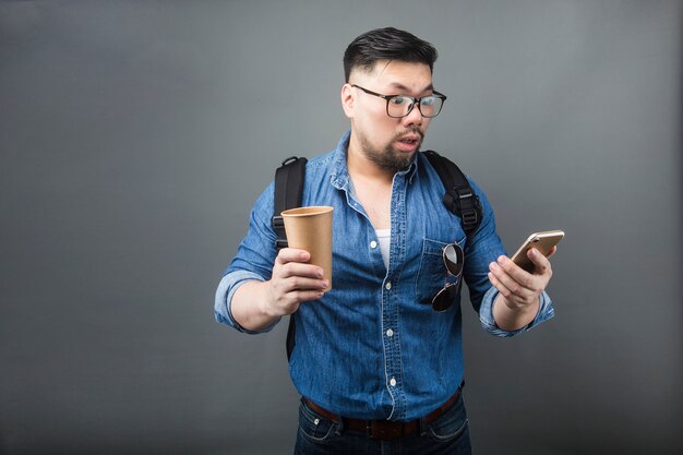 Ein Mann, der mit Erstaunen das Telefon betrachtet