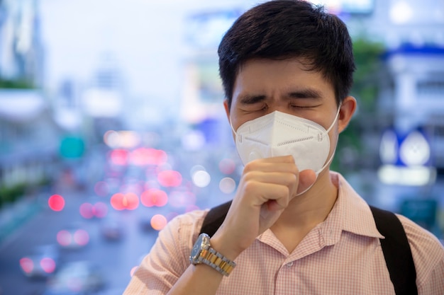 Ein Mann, der Mundmaske gegen Luft Smogverschmutzung mit PM 2.5 in Bangkok Stadt, Thailand trägt.