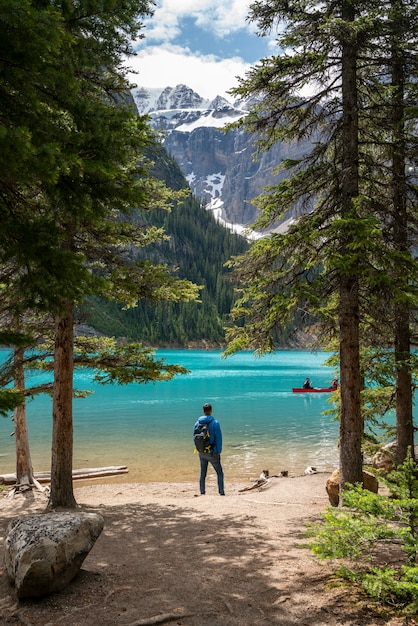 Ein Mann, der vor Moraine See steht