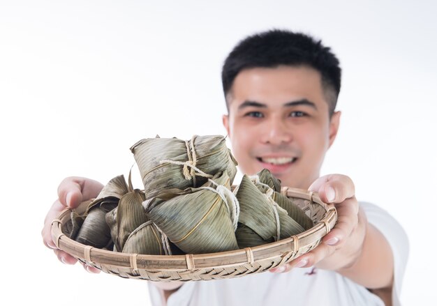 Ein Mann, der Zongzi, Reisknödel für Drachenbootfest hält