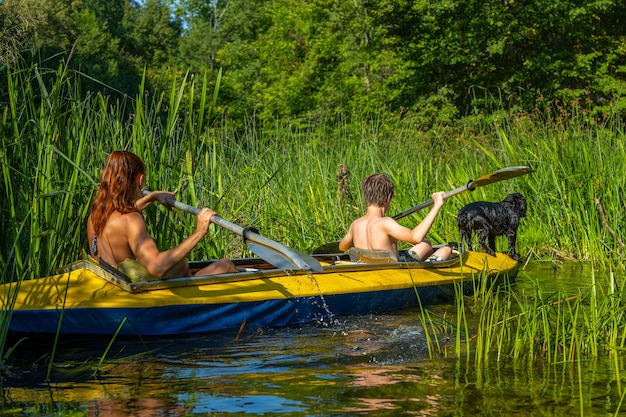 Ein Mann, eine Frau und ein Hund fahren Kajak Rafting auf dem schnellen Fluss Abenteuer Reisen Lifestyle Konzept Fernweh Aktive Wochenendferien wilde Natur im Freien