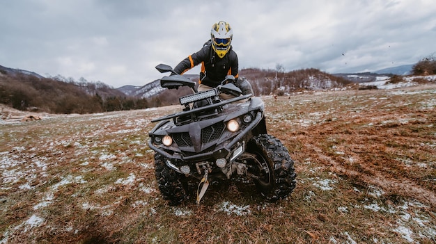 Foto ein mann fährt ein atv in der schlammverwehung und fährt ein atv-quad durch schlamm und schnee