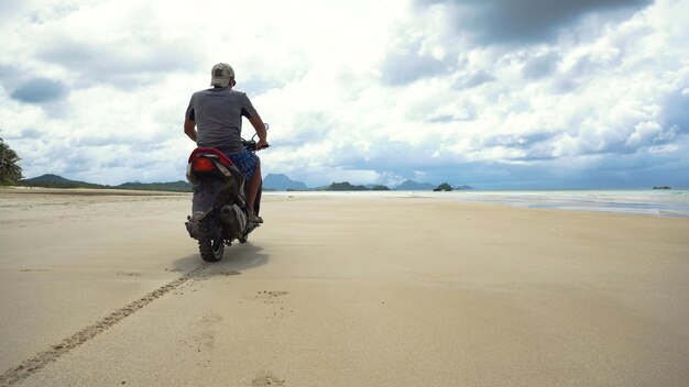 Ein Mann fährt ein Motorrad am Strand