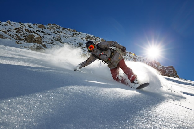 Ein Mann fährt Snowboard auf Schnee gegen den Himmel