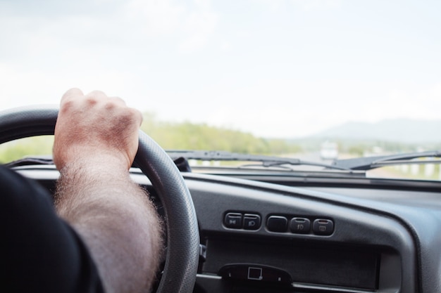 Ein Mann fährt tagsüber ein Auto