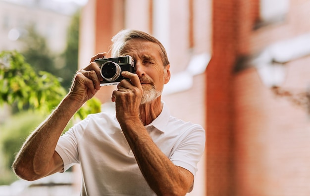 Ein Mann fotografiert gegen ein Gebäude