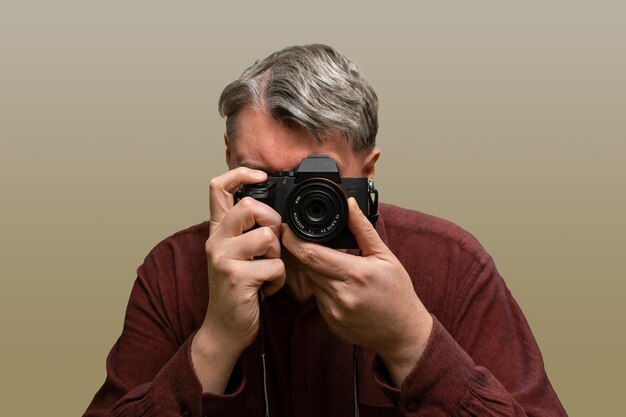 Ein Mann fotografiert mit einer Kamera gegen den Himmel