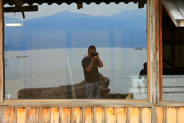 Foto ein mann fotografiert sich selbst von der reflexion auf einem glasfenster