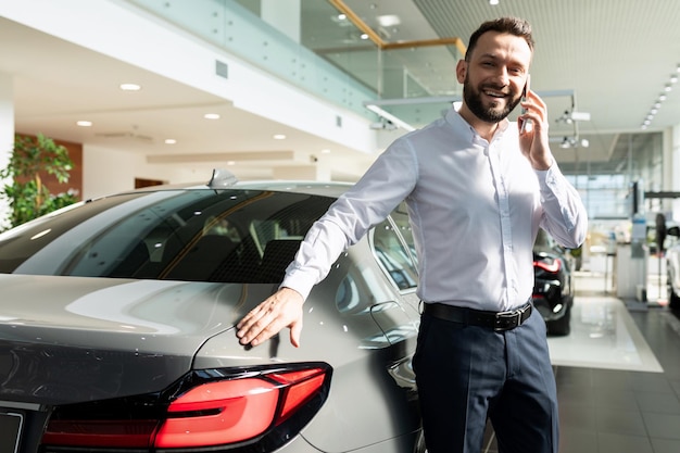 Ein Mann freut sich über den Kauf eines neuen Autos und informiert seine Familie telefonisch darüber