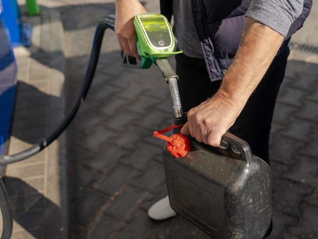 Ein Mann füllt an einer Tankstelle Kraftstoff in einen Plastikkanister