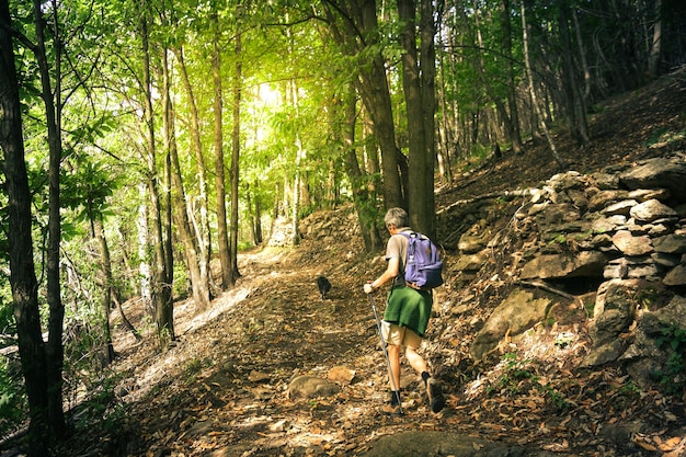 Ein Mann geht im Bergwald, ein Mann mit Rucksack wandert in der Natur, ein Mann geht im Freien wandern.