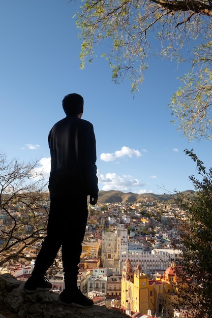 Ein Mann genießt das lebendige Stadtbild von Guanajuato, Mexiko, umgeben von Natur und ikonischen Sehenswürdigkeiten