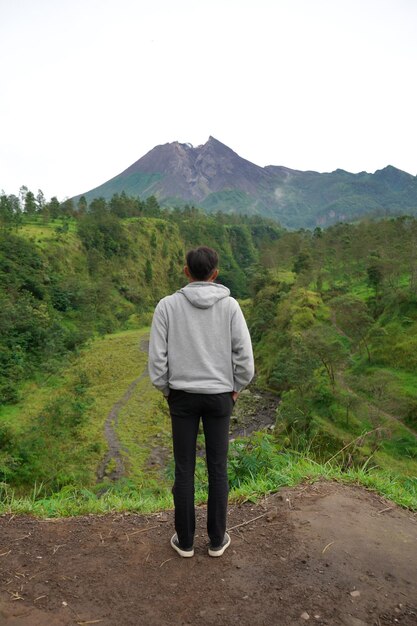 Ein Mann genießt morgens die schöne Aussicht auf den Vulkan