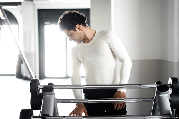 Ein Mann gesunder Lebensstil Athlet macht Langhantel-Übungen Cardio-Training im Fitnessstudio Fitness-Konzept