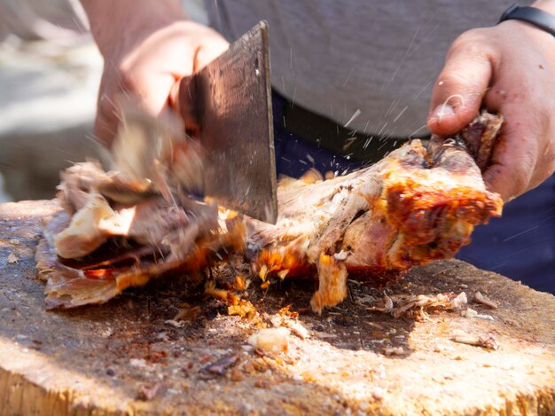 Ein Mann hackt Fleisch mit einem Axtmesser traditionelles Essen für Ostern in Griechenland