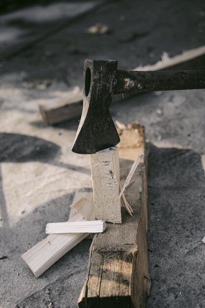 Ein Mann hackt Holz mit einer Axt, um ein Feuer anzuzünden. Hinterhofarbeit