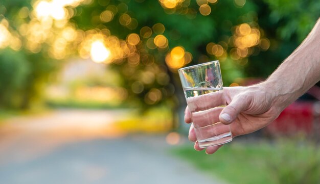 Ein Mann hält ein Glas Wasser in seinen Händen Selektiver Fokus