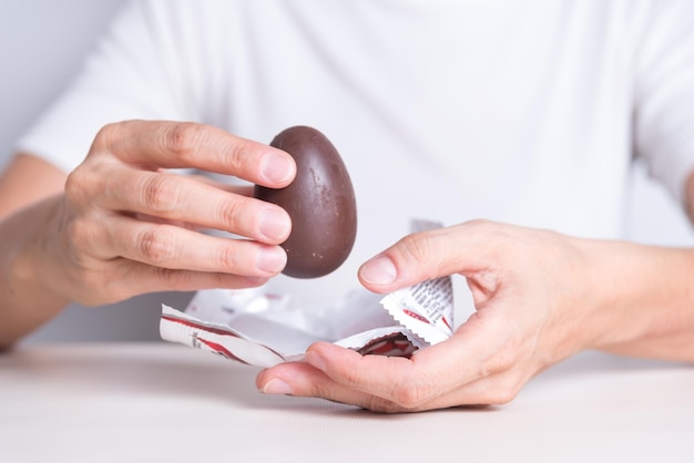 Foto ein mann hält ein schokolade-ei und eine schachtel schokolade