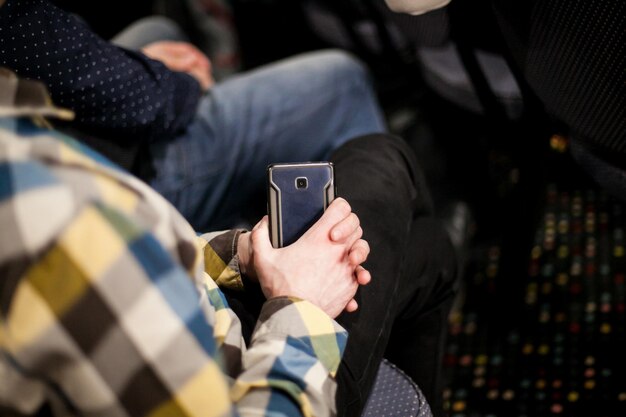 Ein Mann hält ein Smartphone in seinen Händen, Nahaufnahme von Händen mit einem Telefon