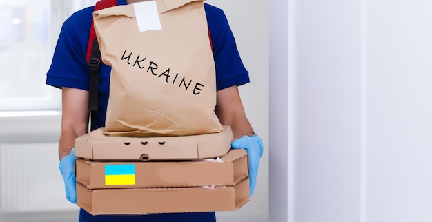 Ein Mann hält eine Hilfskiste für ukrainische Flüchtlinge und arme Bürger, die sich in einem Krieg zwischen der Ukraine und Russland befinden Humanitäres Hilfskonzept Spende für Flüchtlinge