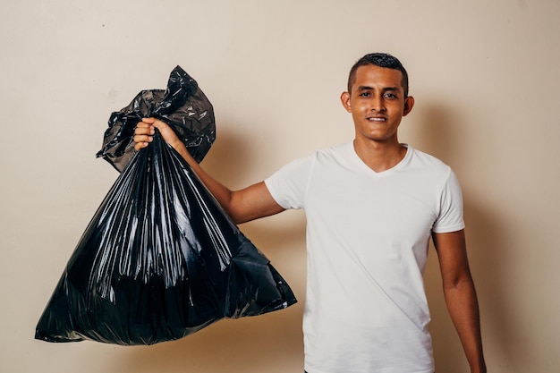 Ein Mann hält einen schwarzen Müllsack in der Hand