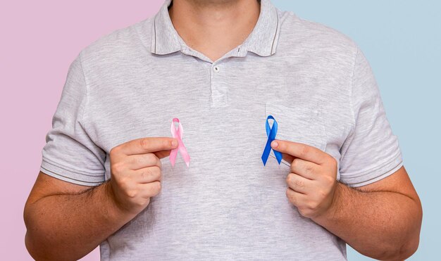 Ein Mann hält zwei rosa und blaue Bogen für die Kampagnen Pink October und Blue November, um das Leben zu unterstützen und das Bewusstsein für Krebs zu schärfen.