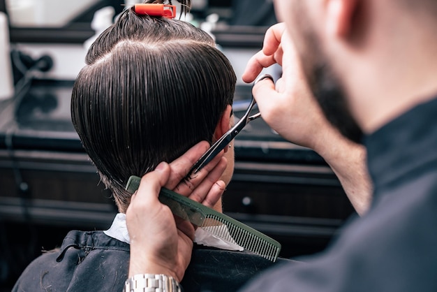 Ein Mann hängt in einem Schönheitssalon herum. Haarschnitt und Styling im Barbershop. Männerpflege für Bart und Haare.