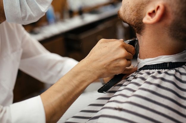 Ein Mann hat sich in einem Friseurladen die Haare am Bart geschnitten