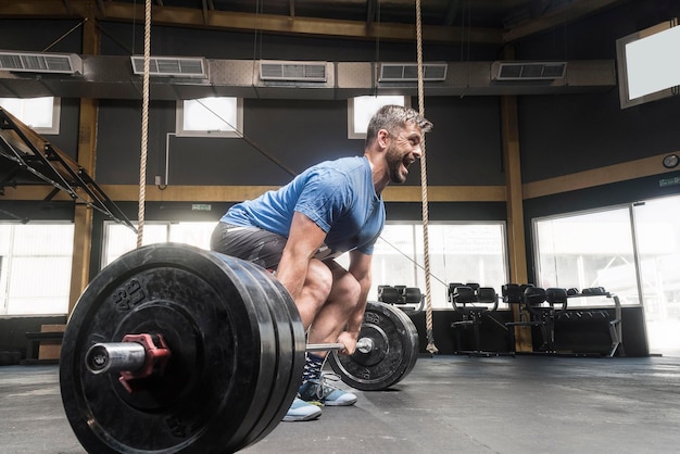 Foto ein mann hebt gewichte im fitnessstudio