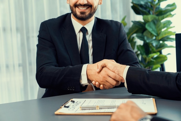 Ein Mann im Anzug schüttelt einem Mann im Anzug die Hand.