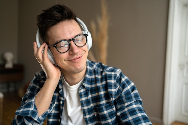 Ein Mann im Büro hört Musik mit Kopfhörern und macht eine Pause