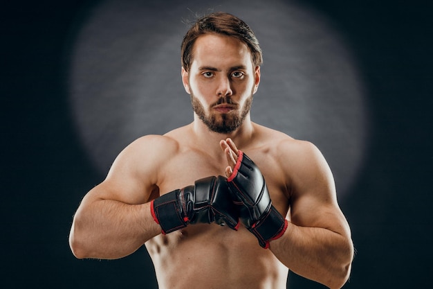 Ein Mann in Boxhandschuhen Ein Mann Boxen auf schwarzem Hintergrund Das Konzept eines gesunden Lebensstils