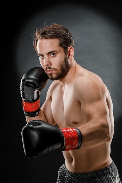 Ein Mann in Boxhandschuhen Ein Mann Boxen auf schwarzem Hintergrund Das Konzept eines gesunden Lebensstils