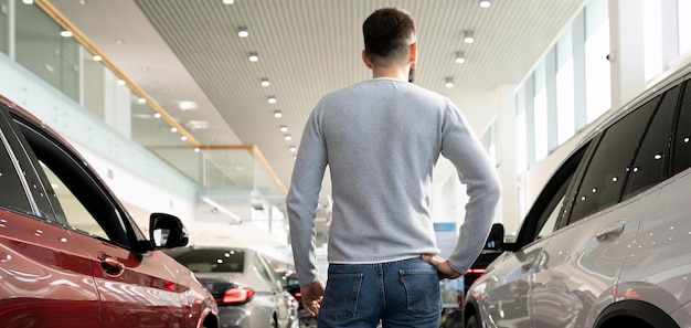 Ein Mann in einem Autohaus sucht sich ein neues Auto aus