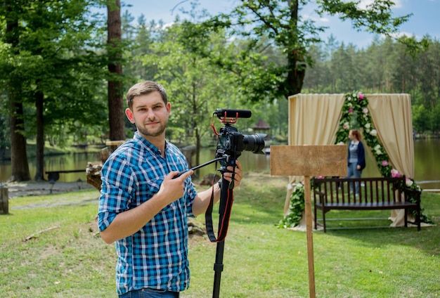Ein Mann in einem Hemd mit einem Einbeinstativ und einer Kamera