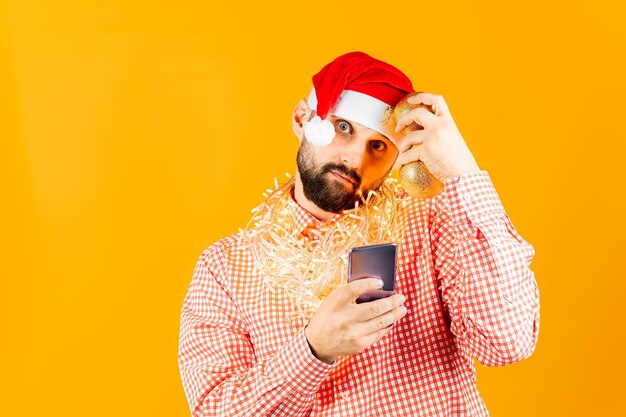 Ein Mann in einem karierten Neujahrshemd, der ein Telefon vor sich hält und überrascht guckt