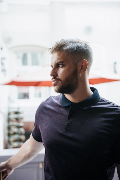 Ein Mann in einem purpurroten Polo und in einer Aufstellung für die Werbung der Kleidung der Männer. Dreharbeiten für Herrenbekleidungsgeschäft