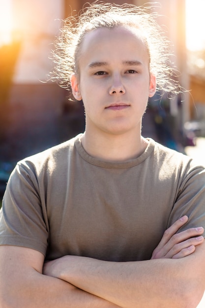 Ein Mann in einem T-Shirt faltet seine Arme und sieht selbstsicher aus