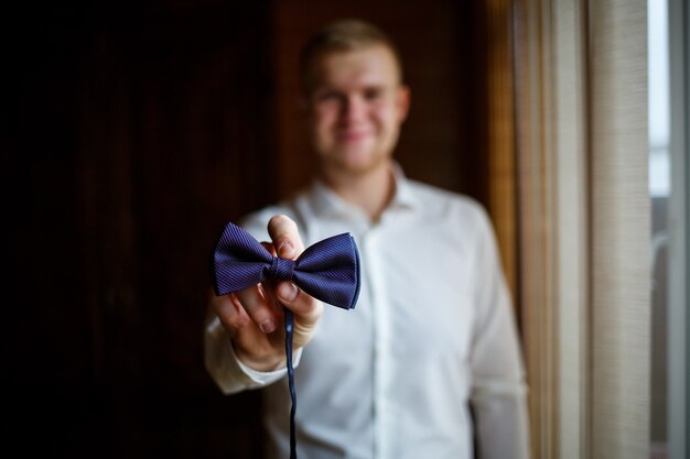 Ein Mann in einem weißen Hemd und Hosenkleidern an einem Hochzeitstag.