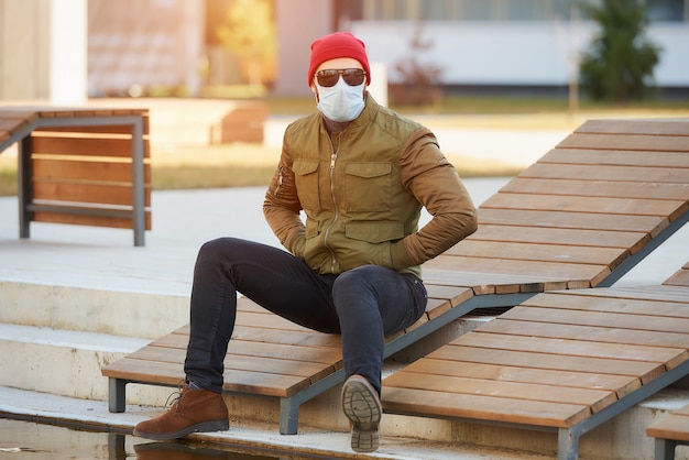 Ein Mann in einer medizinischen Gesichtsmaske, um das verbreitete Coronavirus in der gemütlichen Straße zu vermeiden.