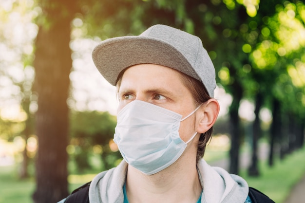 Ein Mann in einer medizinischen Maske geht in den Park