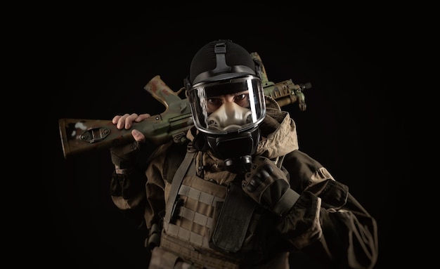 Ein Mann in einer Militäruniform und einer Gasmaske hält eine Waffe mit einem wütenden Gefühlsausdruck