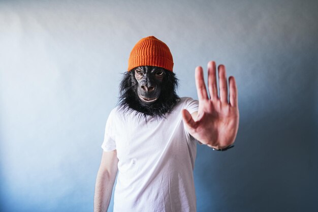 Foto ein mann in einer schimpansenmaske, der mit der hand aufhört