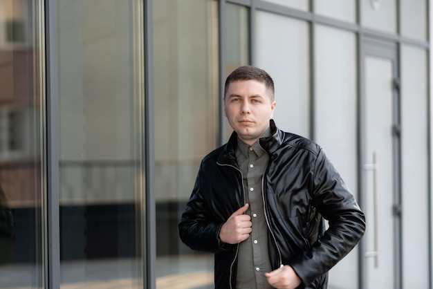 Ein Mann in einer schwarzen Lederjacke geht an einem Supermarktfenster entlang