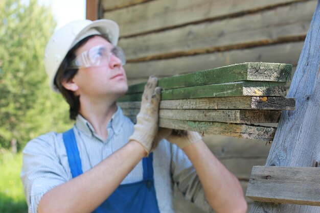 Foto ein mann in gestalt eines baumeisters repariert ein haus