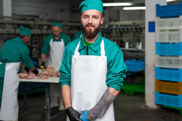 Ein Mann in grüner Uniform steht in einer Fabrik mit einem Schild mit der Aufschrift „Fleisch“