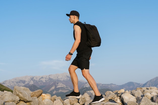 Ein Mann in schwarzer Kleidung beim Wandern in den Bergen Blick auf die Berge und blauer Himmel