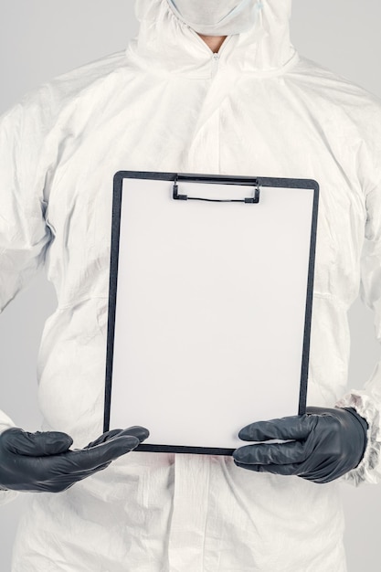 Ein Mann in Uniform und Gesichtsmaske mit einem Plakat Konzept des Gesundheitswesens und der Medizin