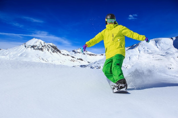 Ein Mann in voller Länge beim Snowboarden auf einem schneebedeckten Berg gegen den Himmel